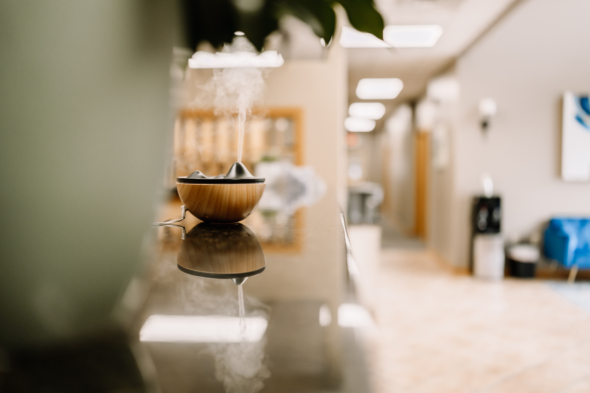 A wooden diffuser releasing a soft plume of steam in the MK Counseling hallway