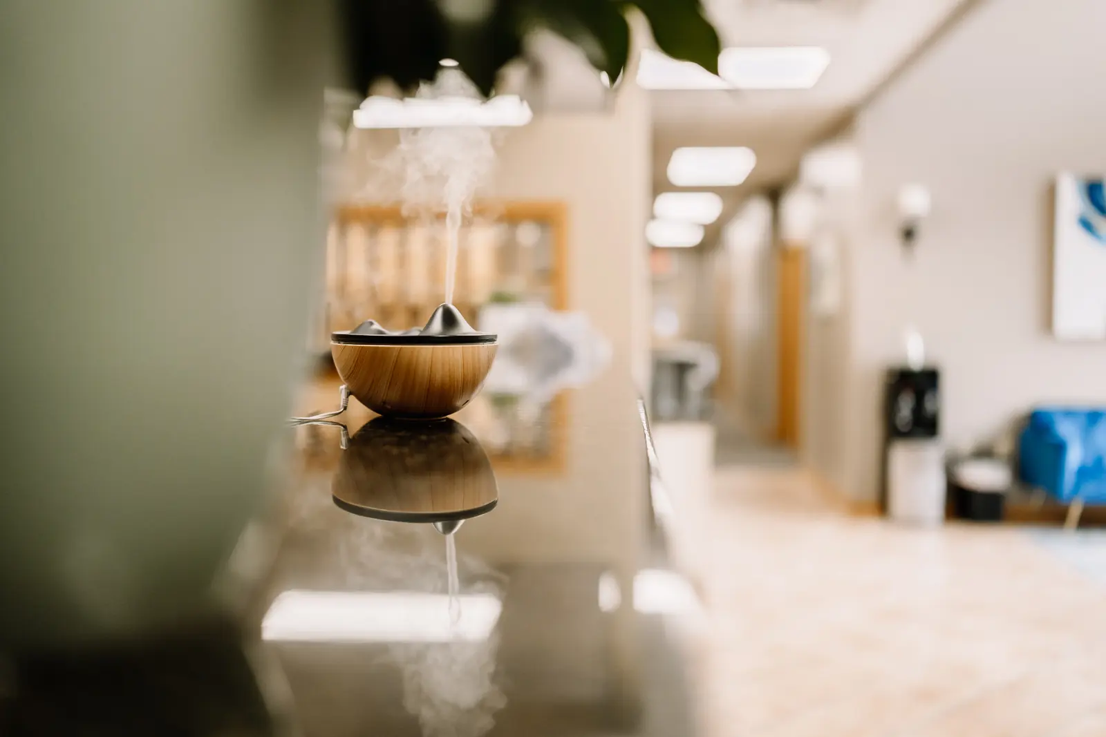 A wooden diffuser releasing a soft plume of steam in the MK Counseling hallway