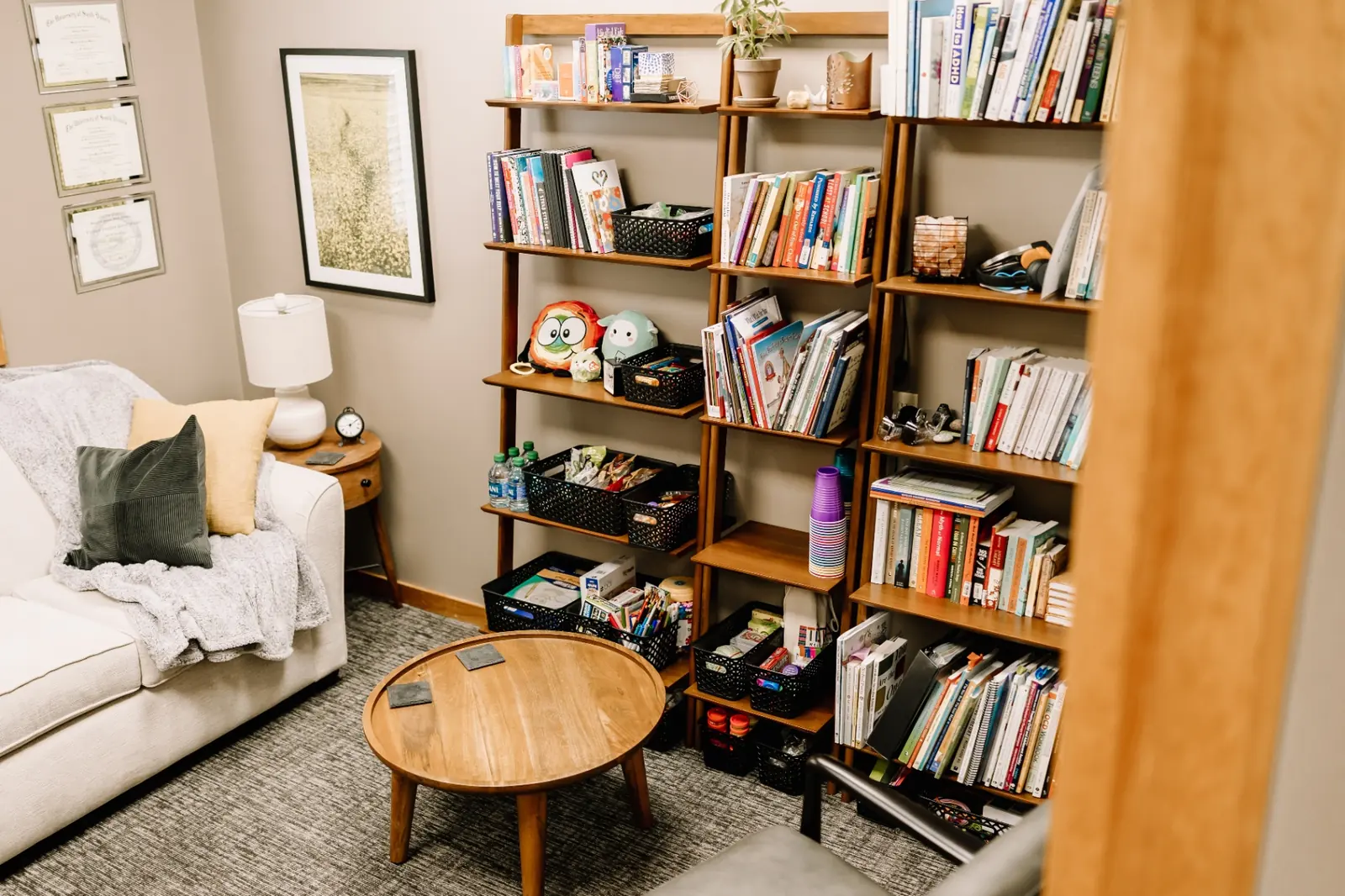 MK Counseling therapy room with bookshelves of resources, soft couch, and warm lamp light